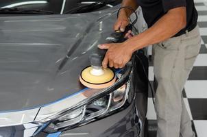 Car detailing - Male mechanic holding car polishing machine. Auto industry, car polishing and painting and repair shop.