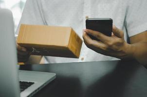 man hand using smart phoneand laptop on table at home, searching information  browsing the internet on web, work from home.Business shopping online concept photo