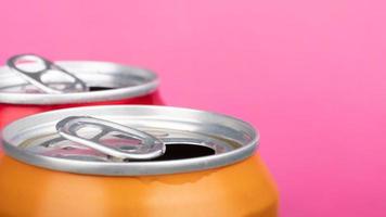 open red and yellow can tin of beer close up on pink background photo