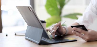 Close up woman hand using credit card and smartphone laptop for buying online shopping photo