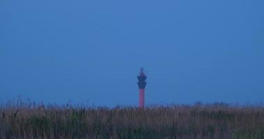 landscape with lighthouse in the fields after sunset video