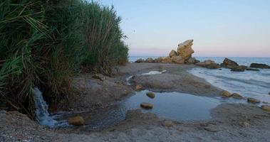 Landschaft mit Meer und Steinen nach Sonnenuntergang video