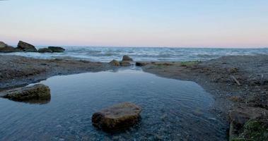 Landschaft mit Meer und Steinen nach Sonnenuntergang video