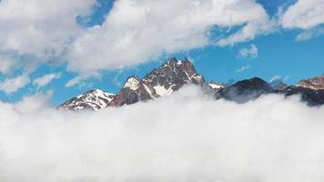 Mountain top panorama coming out of the clouds photo