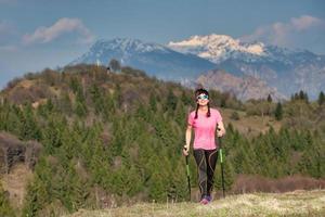 primavera en las montañas entre verde y nieve. una chica solitaria durante una caminata foto