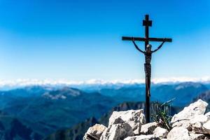 pequeño crucifijo de hierro en la cima de una montaña