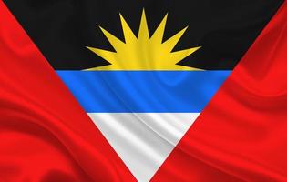 Bandera del país de Antigua y Barbuda sobre un fondo de tela de seda ondulada foto
