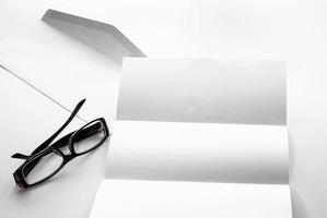 blank of letter paper and envelope with eyeglasses photo