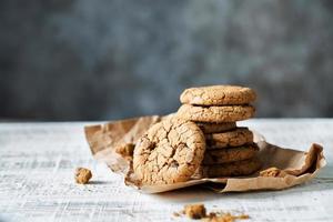 Stack of fresh oatmeal cookies with chocolate lies on a table photo