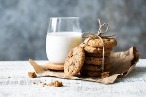 Several fresh oatmeal cookies and a glass of milk photo