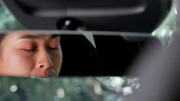 la vue depuis le rétroviseur d'une femme stressée et fatiguée et épuisée qui pleure dans la voiture. video