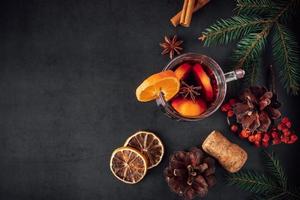 Traditional Christmas warming mulled wine. Hot drink with spices in glass cup on dark background. photo