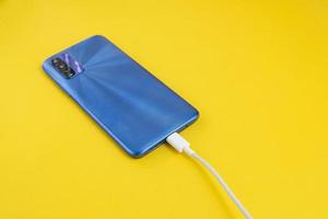 Blue cell phone connected to USB cable type - Charging photo