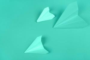 overhead view green paper airplanes mint background photo