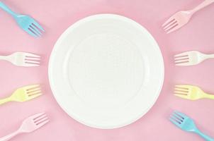 platos de plastico de colores fondo rosa foto