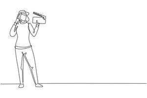 Single one line drawing female film director stands with call me gesture holding clapperboard and prepare camera crew for shooting at studio. Continuous line draw design graphic vector illustration