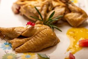 The yellow duck in the long white plate is on the wooden table photo