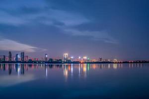 al anochecer, el lago refleja la vista nocturna de la ciudad foto