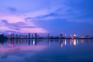 At dusk, the lake reflects the night view of the city photo