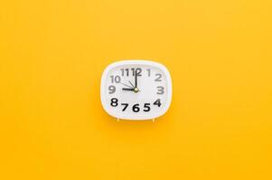 A clock on a yellow background with the time photo