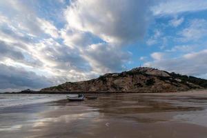 The sky is covered with dark clouds and the beach is cloudy photo