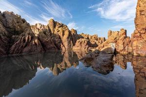 The sea water between the seaside reefs reflects the Yellow reefs and the blue sky photo