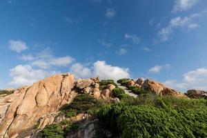 piedras de diversas formas erosionadas por el mar bajo el cielo azul foto