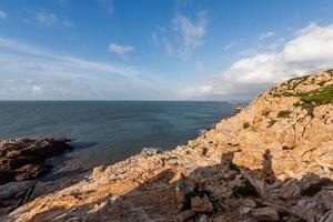 Stones of various shapes weathered by the sea under the blue sky photo