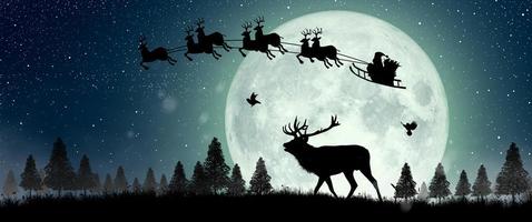 Silhouette of Santa Claus flying over the full moon photo