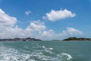 The sea and coastline under blue sky and white clouds photo