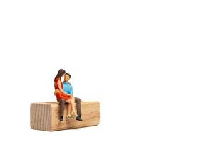 Pareja de personas en miniatura sentada en una silla de madera y espacio para tex foto