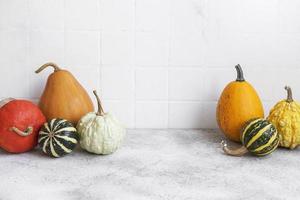 Pumpkin decor on the table over white tile background. photo