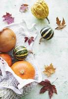 Autumn composition with assorted pumpkins in eco string bag