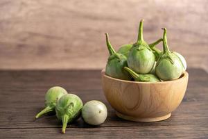 Green eggplant fresh vegetable in wooden bowl with copy space. photo