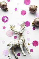 Fondo festivo navideño con hermosos ciervos, bolas doradas y confeti. foto