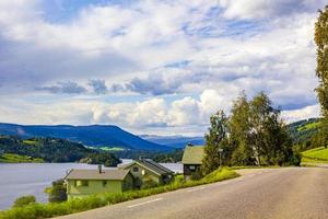 Conduciendo por Noruega en la aldea de verano, montañas y vistas al fiordo.