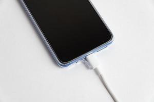 teléfono celular azul conectado al tipo de cable usb - cargando foto