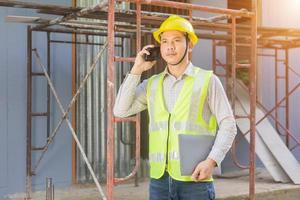 A male engineer looks at the floor plan at the construction site. photo