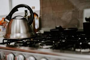 Selective focus shot of tea kettle with boiling water on a gas stove
