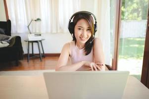 Happy woman wearing headset having video conference photo