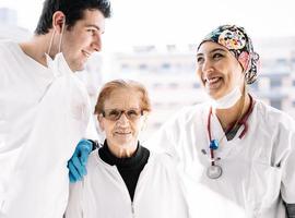 doctores alegres y paciente sonriendo juntos foto