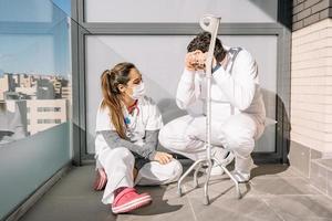 Tired doctors relaxing on terrace during working day photo