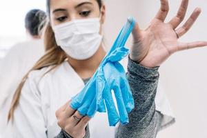 Doctor taking off gloves after work in hospital photo