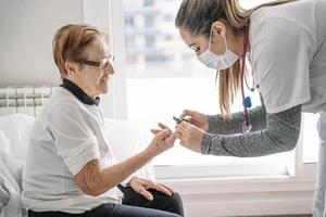 Doctor diagnosing blood pressure of senior woman photo