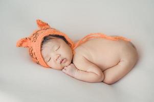 Asian newborn baby sleeping on bed photo