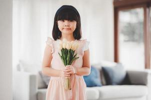 little Asian girl daughter holding bouquet of flowers photo