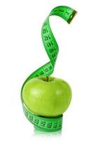 Manzana verde con cinta métrica aislado en blanco