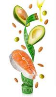 Salmon, avocado, almonds, olives and oil flying around measuring tape. Ketogenic diet and weight loss concept. photo