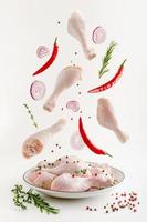 Spicy marinated raw chicken legs or drumsticks levitation. Flying food concept. photo