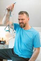 Unhappy shocked man with chronic breathing issues surprised by using  CPAP machine sitting on the bed in bedroom. Healthcare, CPAP, Obstructive sleep apnea therapy, snoring concept photo